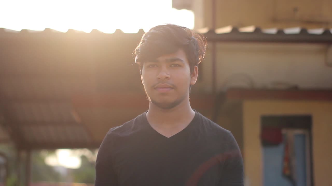 Portrait of young Asian boy coming forward near a camera with selective focus mid shot