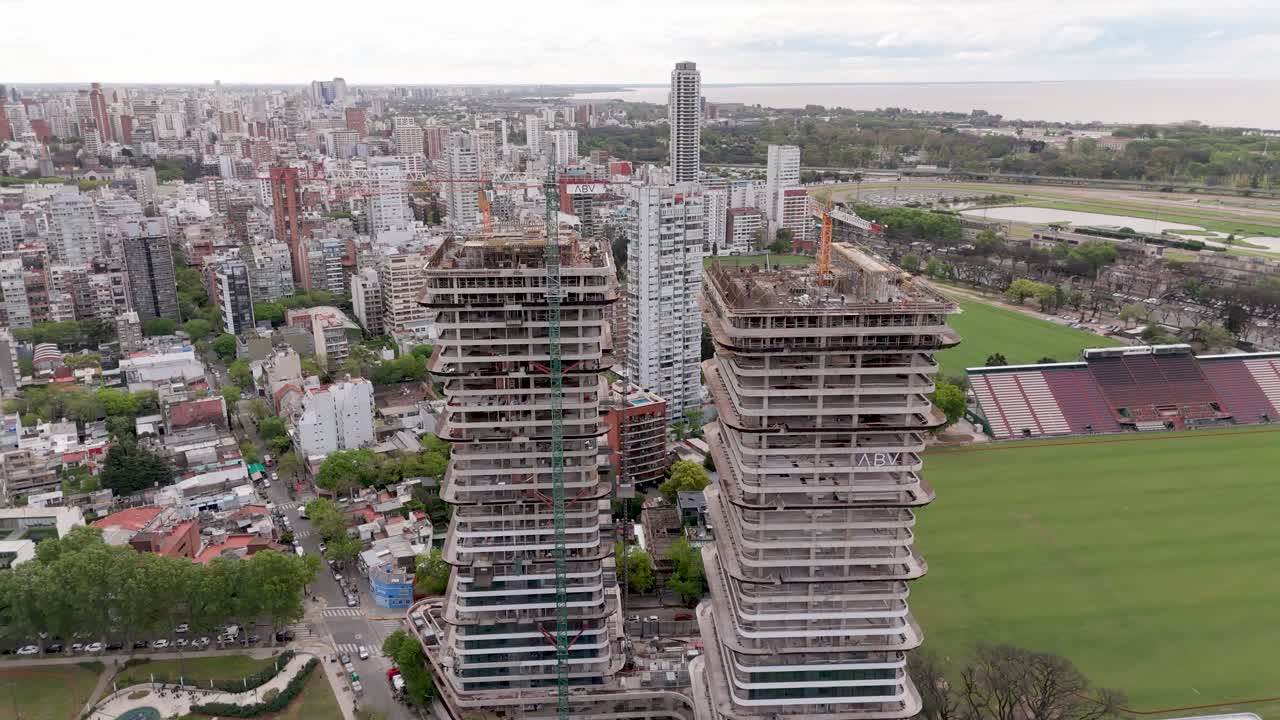 Buenos Aires towers under construction next to a sports field, vibrant city view