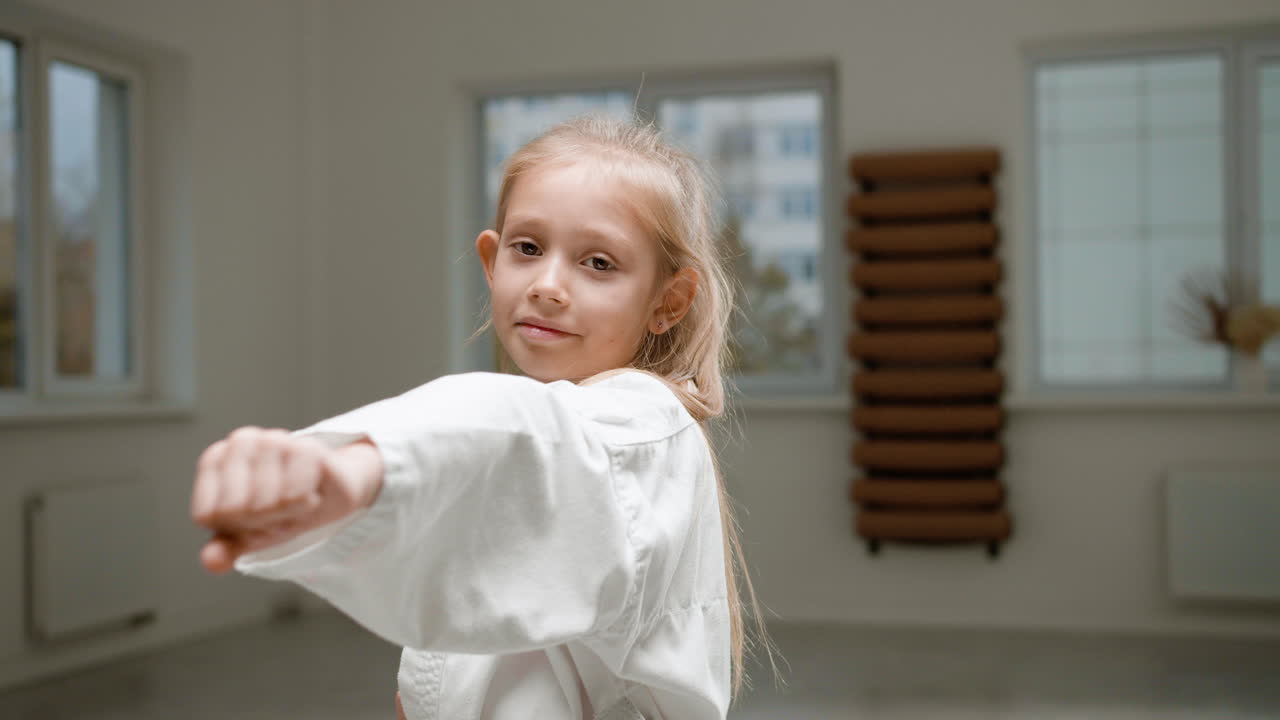chica en kimono blanco en la clase de artes marciales