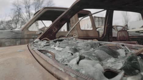 parabrisas de coche roto y derretido de un sedán oxidado - secuelas de un incendio forestal - 4k