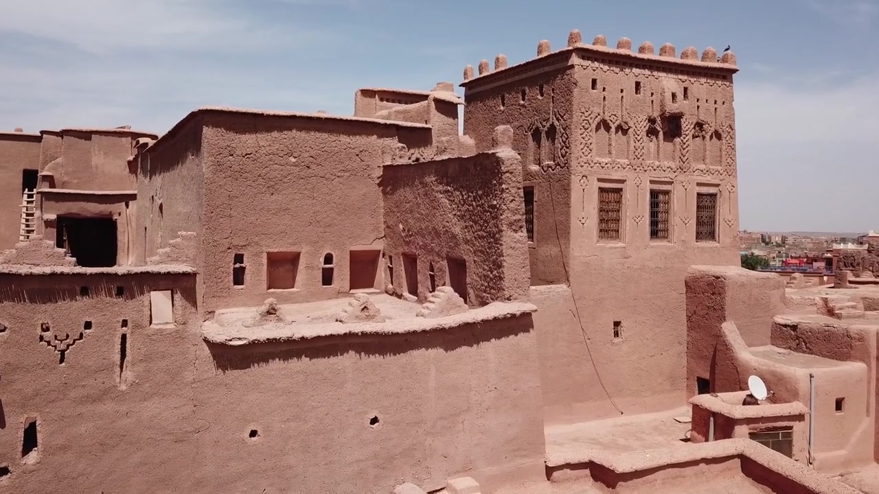 Gros plan détaillé des murs de kasbah traditionnels à Aït Benhaddou, Maroc, présentant des symboles décoratifs berbères uniques et une texture en pisé de terre. Idéal pour les visuels culturels, architecturaux et historiques.