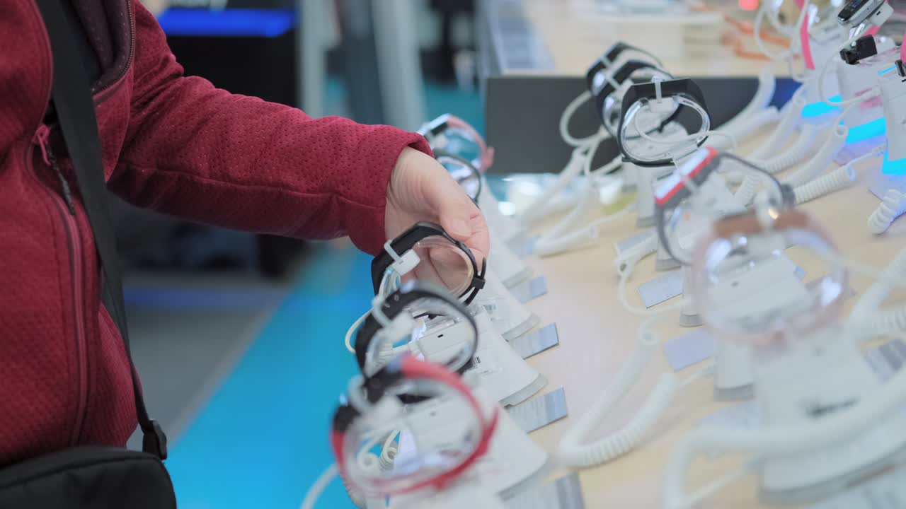 한 여성이 전자제품 가게에서 시계를 구입합니다.