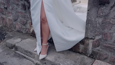 elegant bride in white wedding dress and high heels posing outdoors