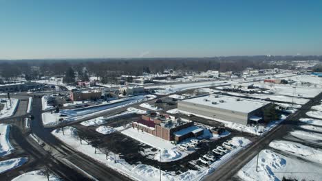 aerial view of small american town, suburb area covered in snow in sunny winter day
