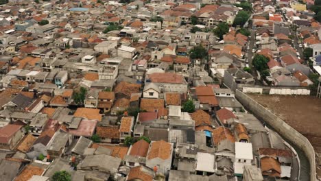 Toma-Aérea-De-Pájaro-Del-Distrito-Pobre-De-Yakarta-Con-Casas-Antiguas-Destruidas-Durante-El-Día-Nublado