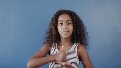 Happy-african-american-girl-using-sign-language-on-blue-background,-slow-motion