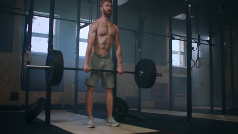 Plano-Amplio-De-Un-Joven-Atleta-Caucásico-De-Levantamiento-De-Pesas-Extremo-Trabajando-Con-Una-Barra-Pesada-En-Un-Gran-Gimnasio.