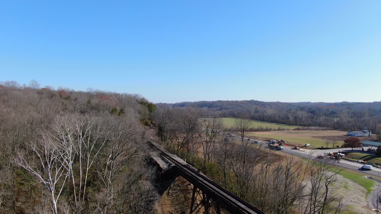 una toma aérea de las vías del ferrocarril que salen de un bosque y llegan al pope lick trestle en louisville, kentucky.