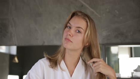 Front-view-of-caucasian-woman-brushing-hair-in-hotel