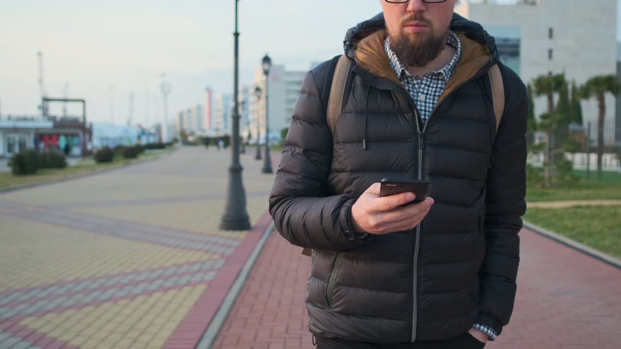 Man Walking and Using Smartphone