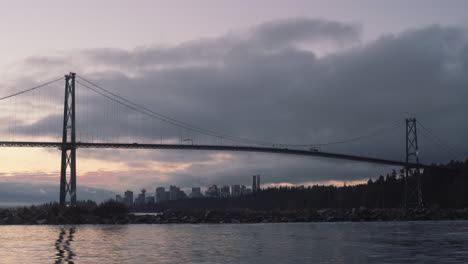 Birds-flying-over-an-Early-morning-view-of-Lions-gate-bridge-shot-from-Ambleside