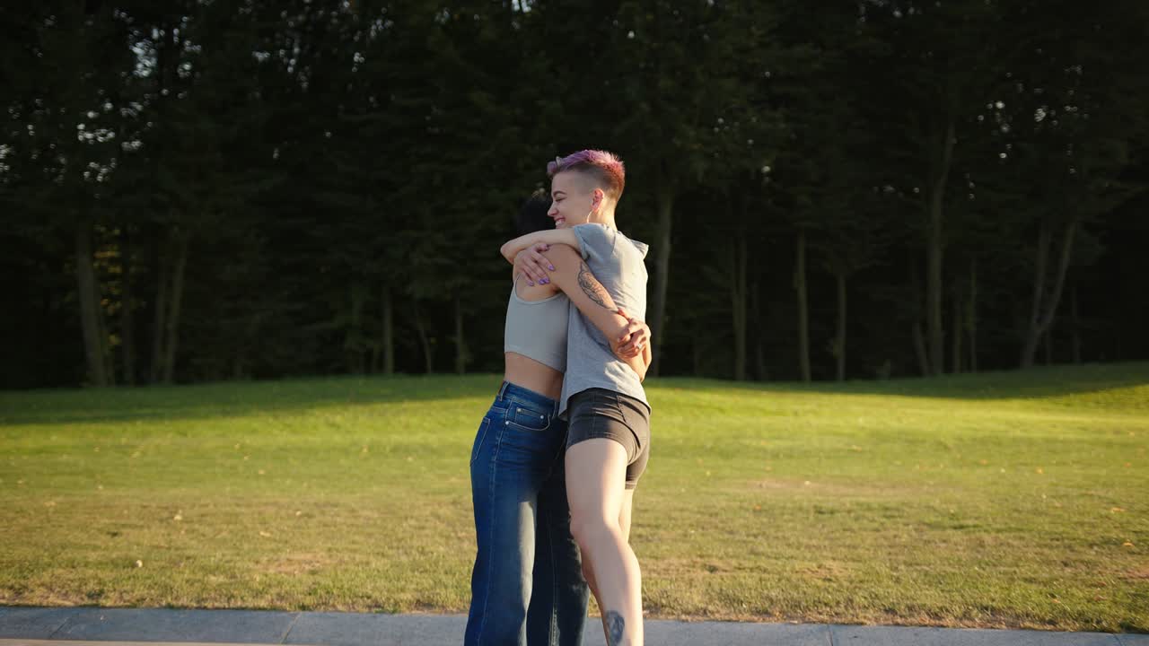 행복한 갈색 레즈비언 여성은 여자친구를 팔에 안고 돌아다닙니다.