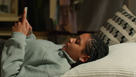 teenage girl using smartphone in bed at night