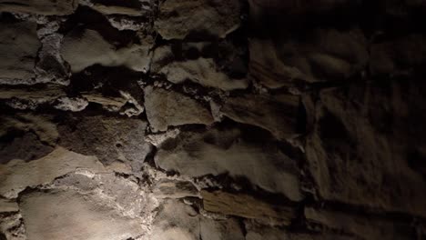 creepy stone wall in basement of old building close up panning shot