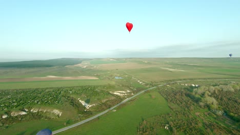 globo de aire caliente en forma de corazón sobre el paisaje panorámico del campo