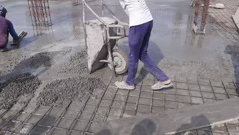 construction trolley or wheelbarrow with sand and cement prepared by workers for concrete at the construction site