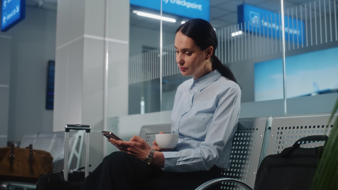 Woman Waiting at Airport with Coffee and Phone
