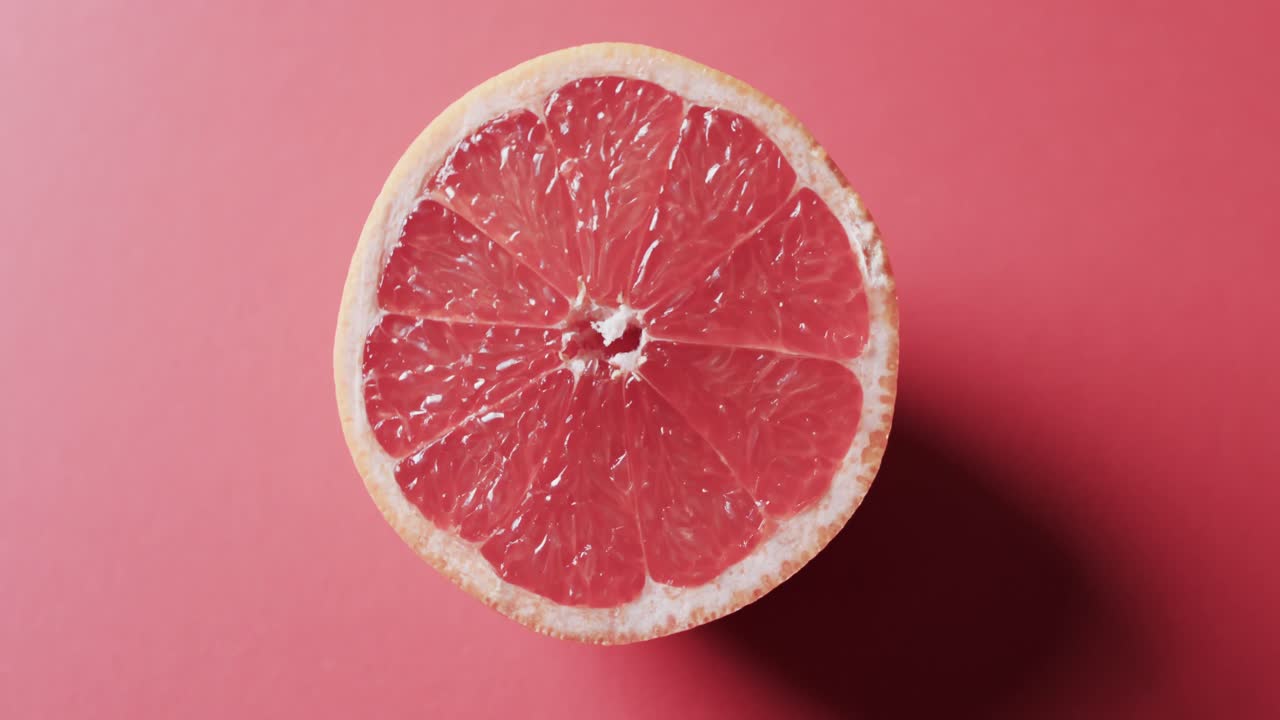 Video di pompelmo rosso affettato con spazio per il testo su sfondo rosso
