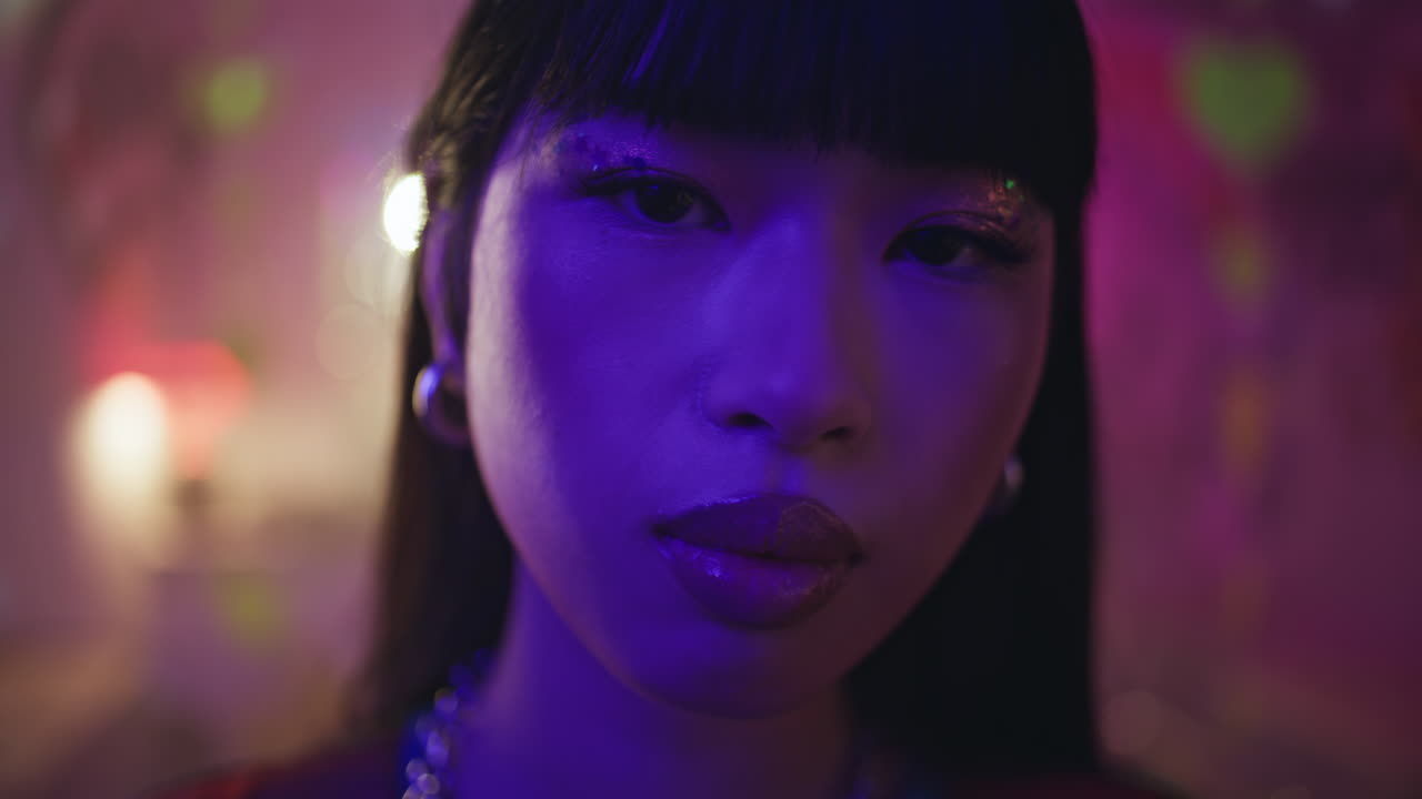 Closeup korean girl clubber in nightclub. Gorgeous woman with shiny makeup