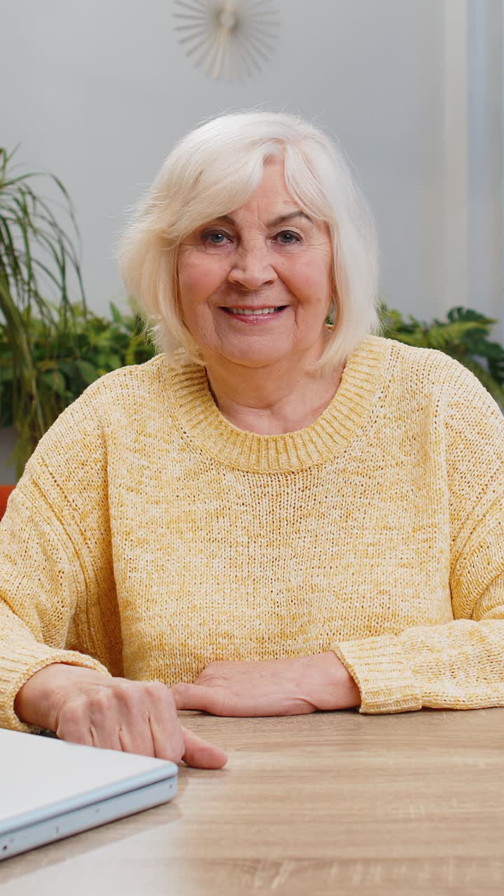 Happy senior old woman looking approvingly at camera showing thumbs up like positive sign good news