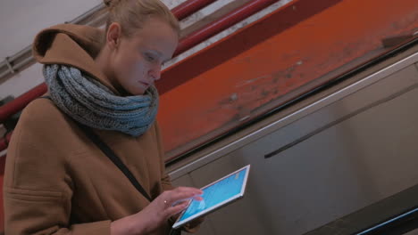 Timelapse-of-woman-with-pad-riding-on-escalator