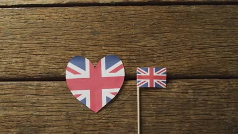 Vídeo-De-Banderas-De-Gran-Bretaña-En-Forma-De-Corazón-Y-Rectángulo-Sobre-Fondo-De-Madera