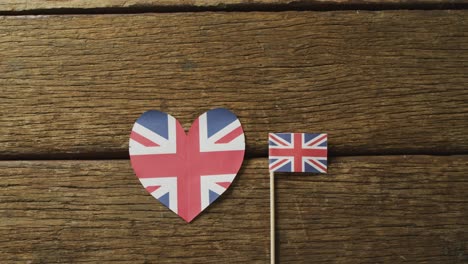 video of flags of great britain in shape of heart and rectangle on wooden background