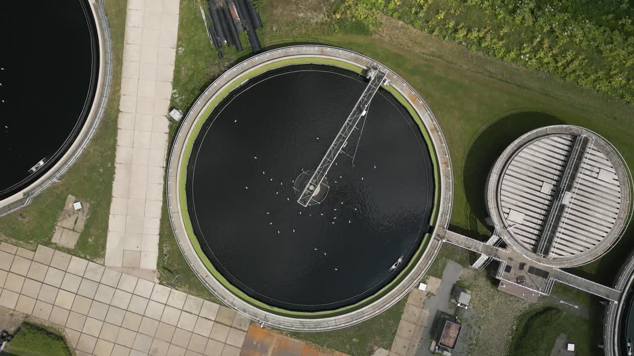 Drone top-down view of a circular wastewater treatment tank with rotating mechanism, part of modern water purification infrastructure