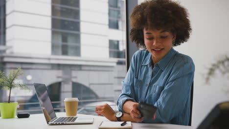 Geschäftsfrau-Im-Modernen-Büro,-Die-Am-Laptop-Arbeitet-Und-Mit-Dem-Mobiltelefon-Spricht