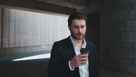 Business-man-drinking-coffee-to-go-outdoors.Male-professional-standing-on-street