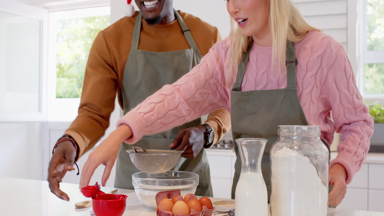 Christmas time, diverse couple baking together in kitchen, enjoying festive holiday preparations