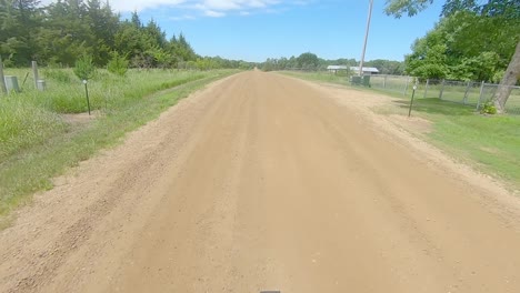 pov fuera de la ventana trasera conduciendo por un camino de ripio en el campo de dakota del sur