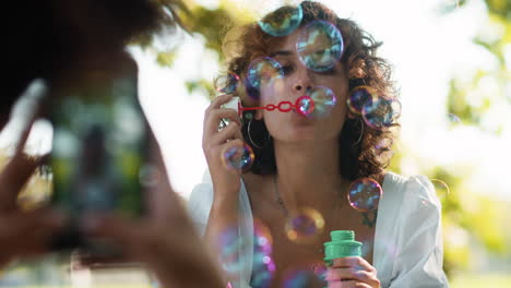 mujer soplando burbujas al aire libre