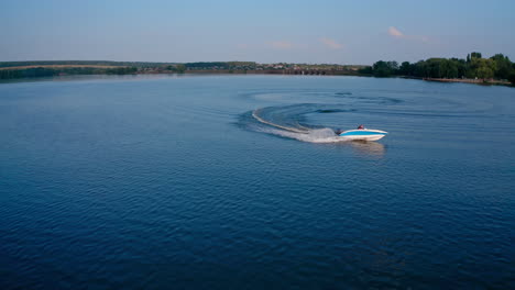 speed boat sailing along river. aerial shot of cruising speed boat on calm river