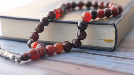 holy book quran and prayer beads on table, close up.