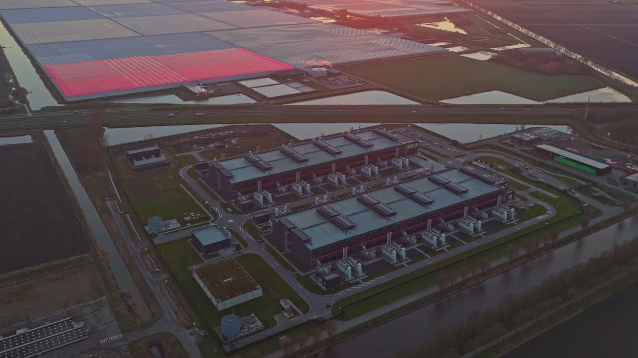 Luftfoto af et moderne datacenter ved solopgang.
