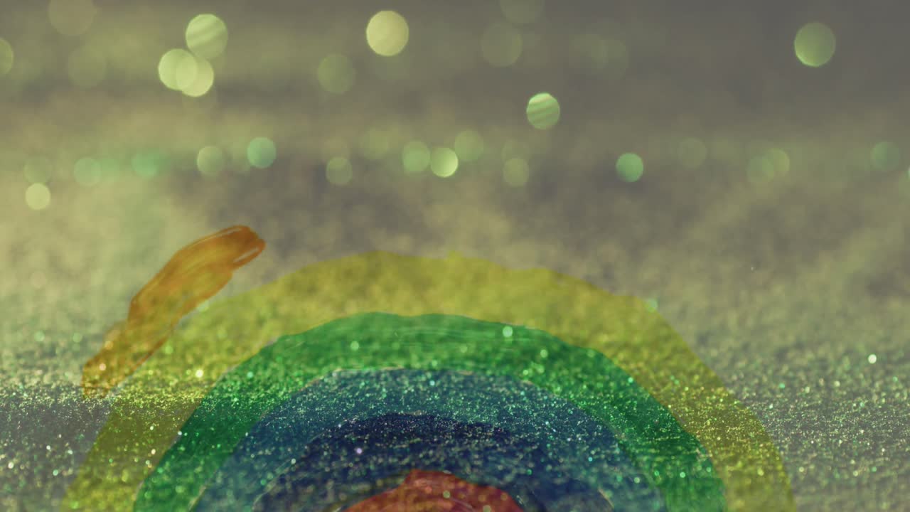 빛나는 모래 위 에 손 으로 그려진 무지개 의 애니메이션 이 배경 에 떨어지고 있다