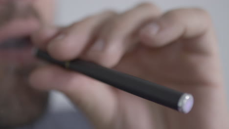 macho adulto fumando un bolígrafo vape