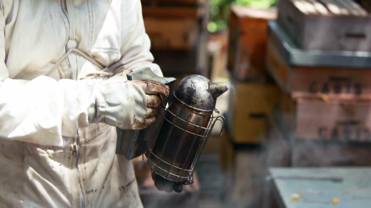 양봉가 들 이 벌 들 을 벌집 에서 멀리 흡연 하고 있다