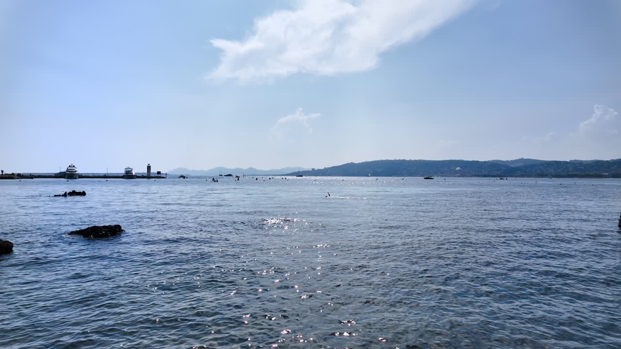 People swimming in the sea and relaxing on the beach in Juan-les-Pins, France