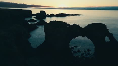 Incredible-drone-aerial-of-coral-sea-arch-and-coastal-lands-during-sunset