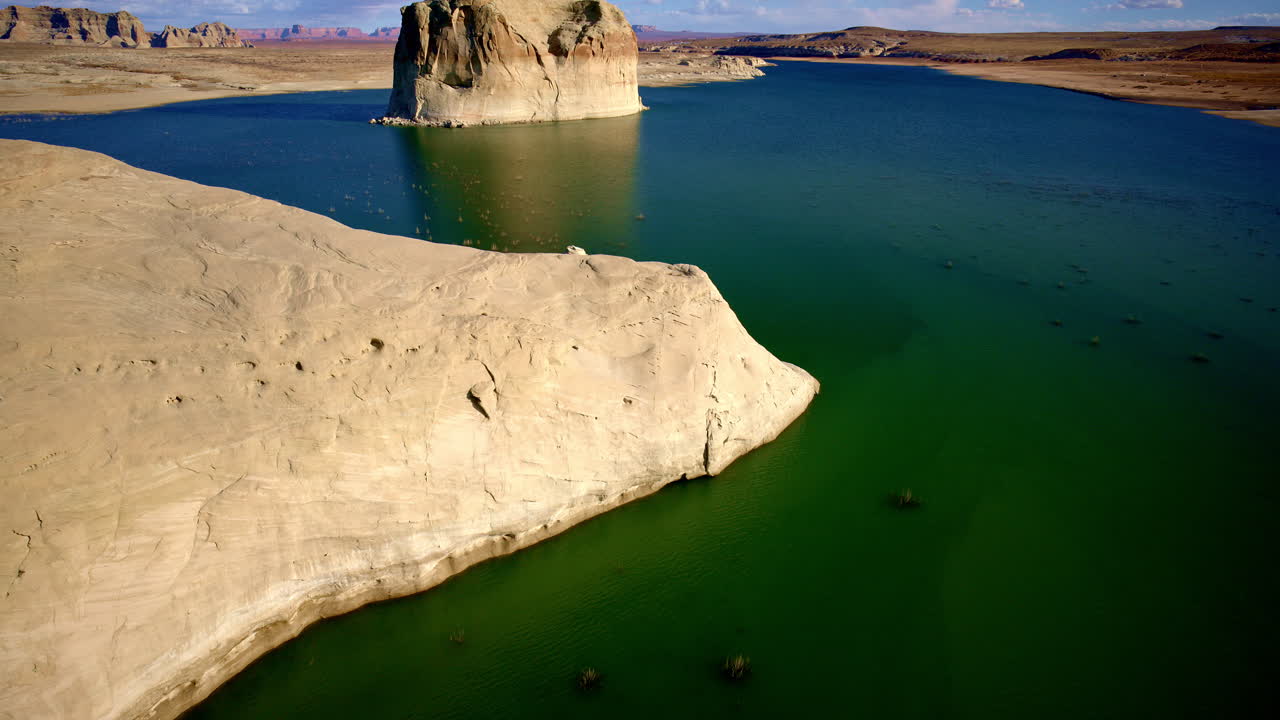 The drone drifts over a dreamlike desert, where canyons weave like veins across a sunbaked earth.