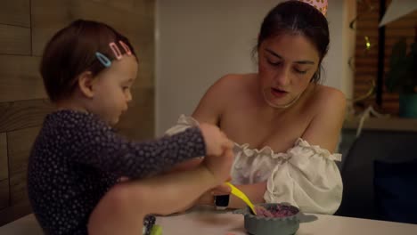 mother feeding baby daughter at birthday party