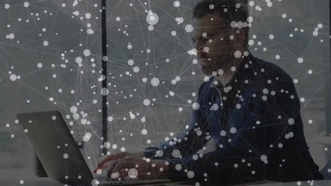 Male worker typing on laptop for work, typing initiating tech network overlay highlighting nodes