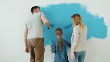 familia pintando una pared juntos