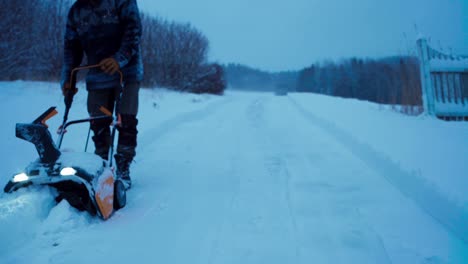 snowblower used by male worker in removing snow in norway