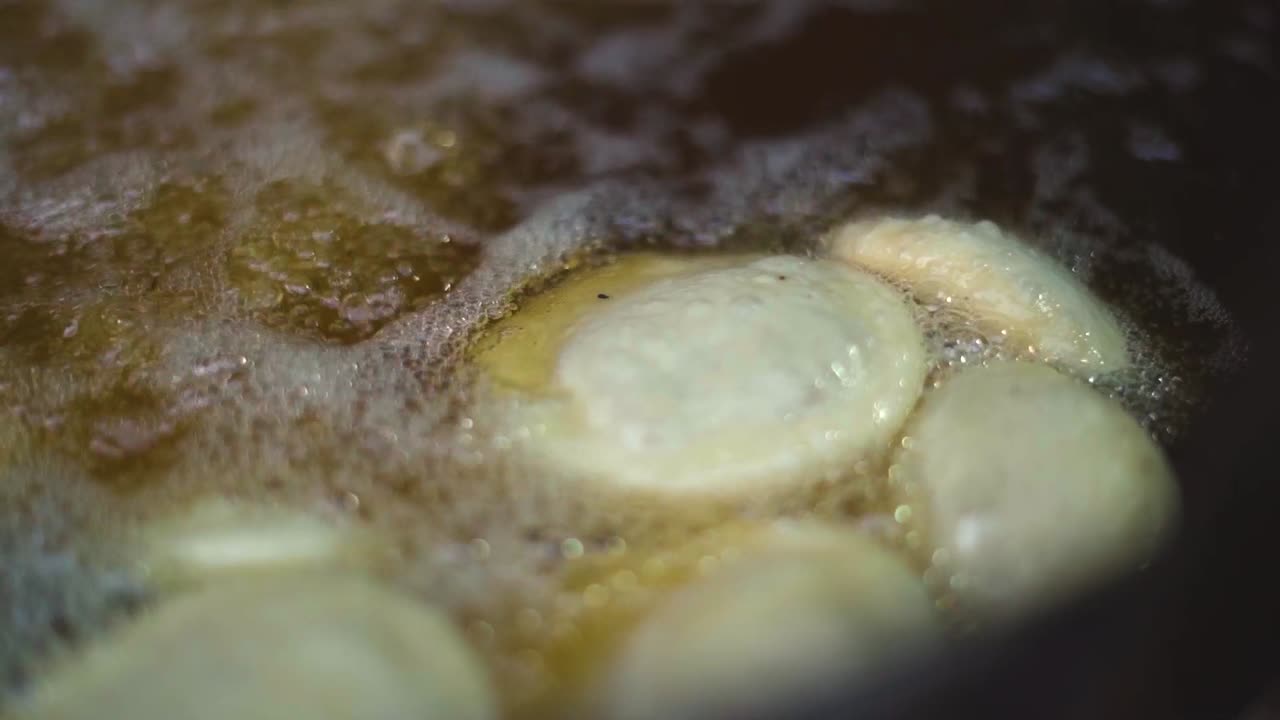 Slow motion shot of frying kachori in hot oil at street breakfast in gwalior india