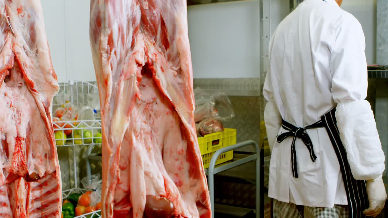 macellaio che controlla la carne nella macelleria 4k