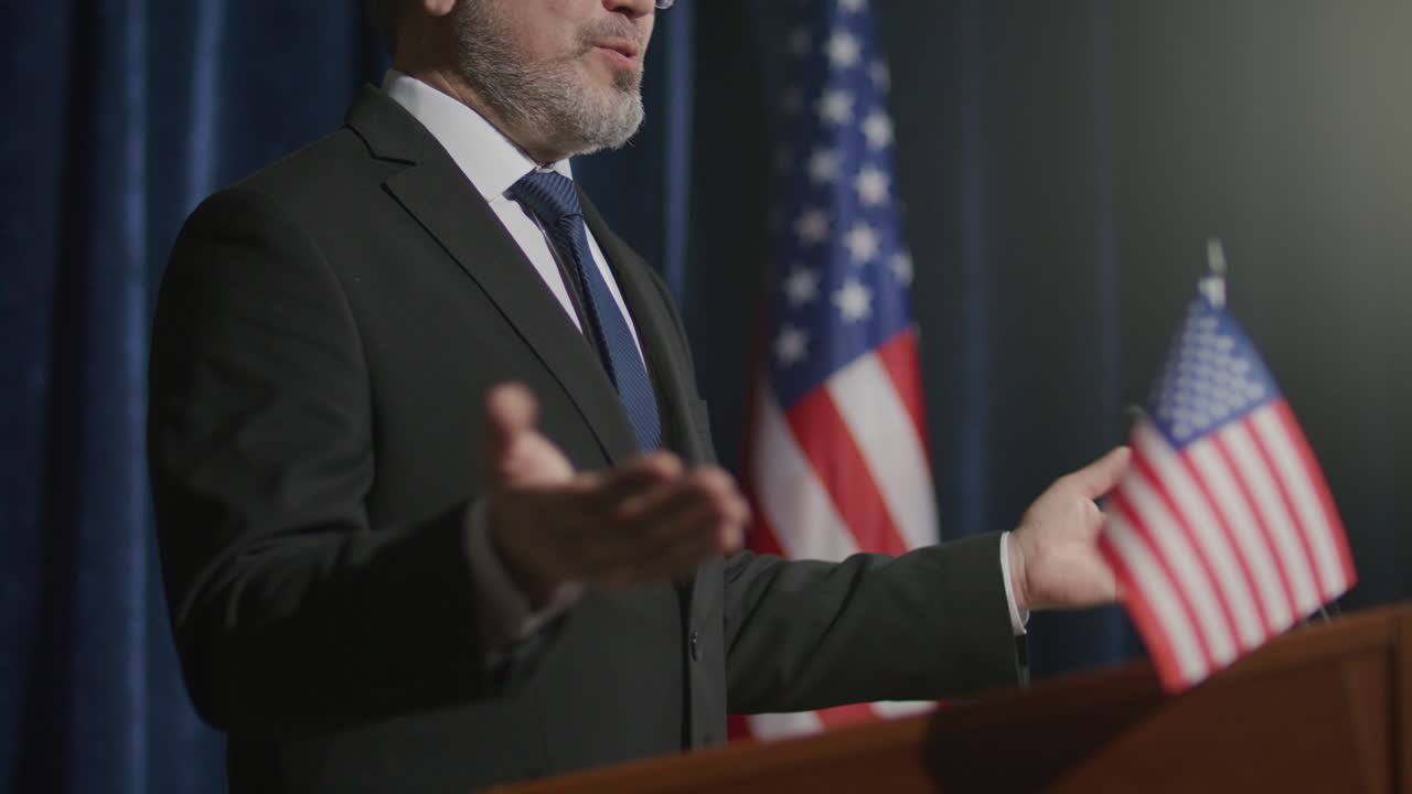 Official Speaking on Stage with US Flags during Political Address