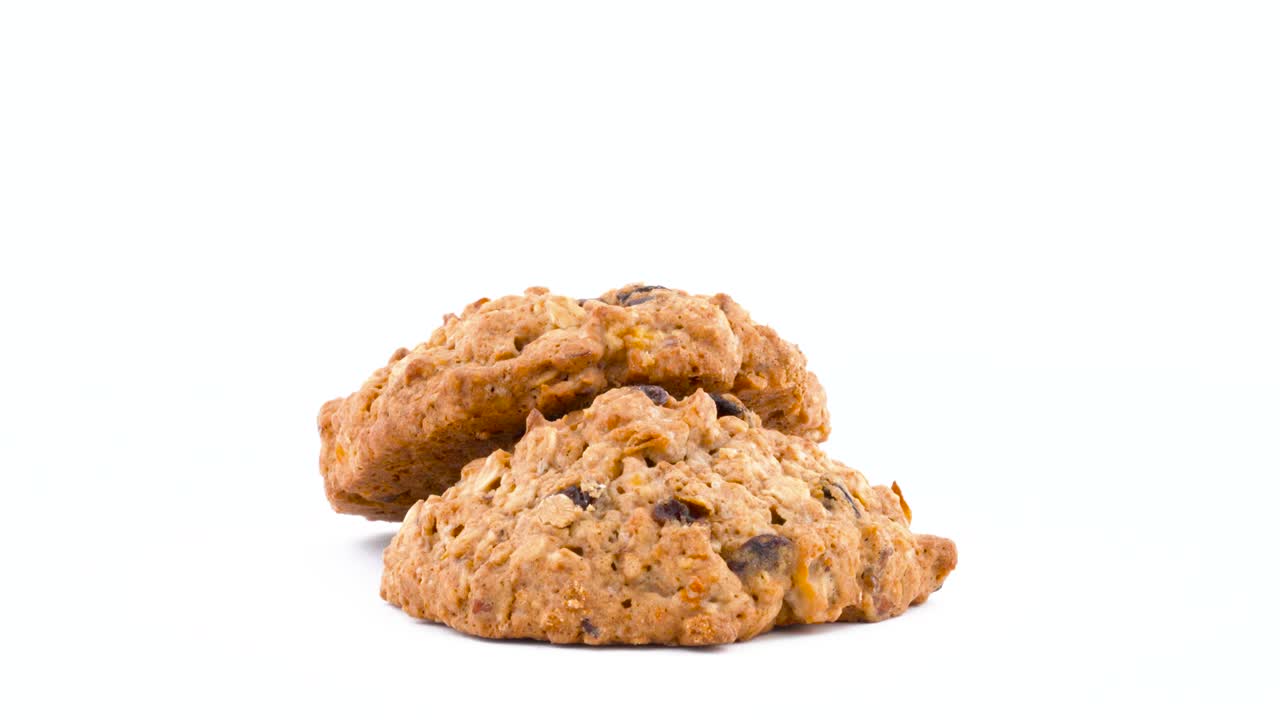 Due biscotti all'avena e uvetta morbidi e gommosi che ruotano sul piatto girevole. Isolati su sfondo bianco. Primo piano. Macro